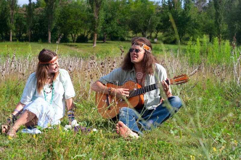 Jeune jeu hippie d'hommes sur la guitare image libre de droits Jeune jeu hippie d'hommes sur la guitare image libre de droits