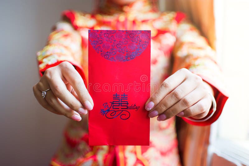 Jeune mariée chinoise donnant à poche rouge l'argent chanceux images stock Jeune mariée chinoise donnant à poche rouge l'argent chanceux images stock