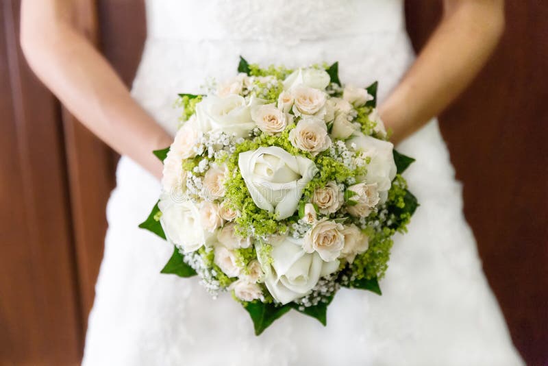 Jeune mariée de plan rapproché tenant le bouquet des roses images stock Jeune mariée de plan rapproché tenant le bouquet des roses images stock