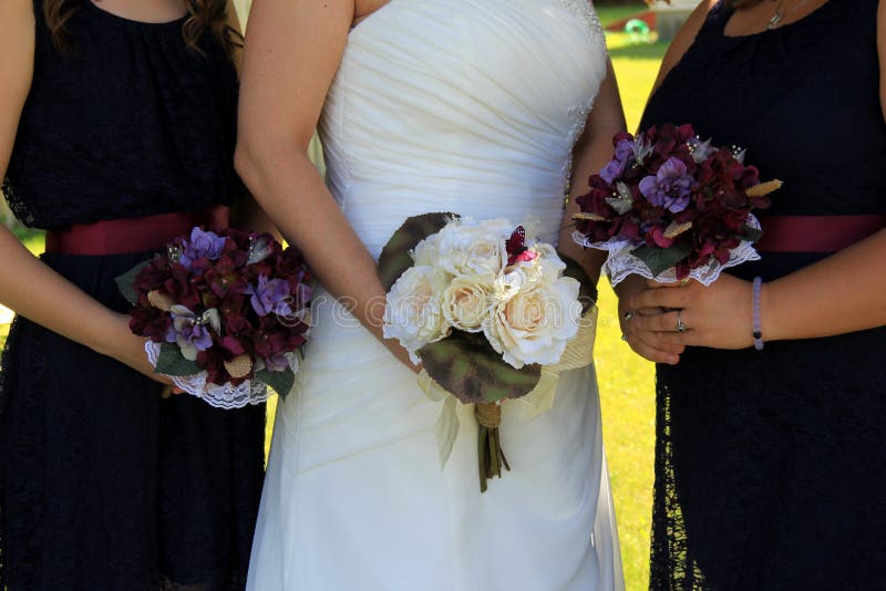 Jeune mariée et demoiselles d'honneur tenant les bouquets floraux photo libre de droits Jeune mariée et demoiselles d'honneur tenant les bouquets floraux photo libre de droits