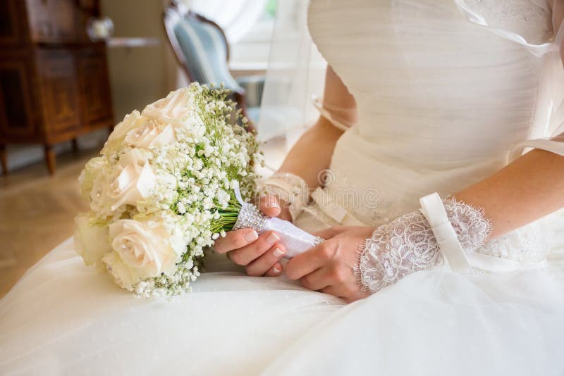 Jeune mariée tenant le bouquet lumineux de mariage images libres de droits Jeune mariée tenant le bouquet lumineux de mariage images libres de droits