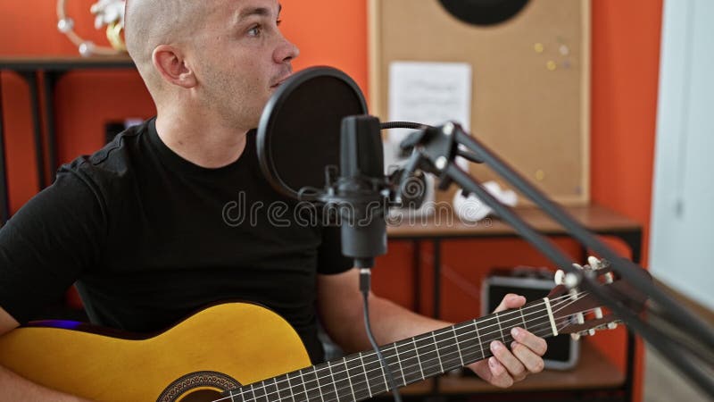 Jeune musicien hispanique chantant une chanson jouant de la guitare classique au studio de musique