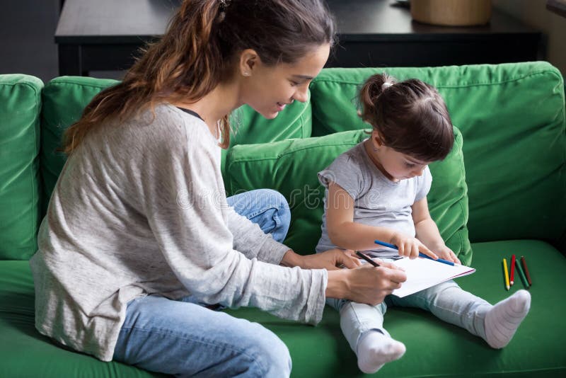 Jeune mère aimante colorant avec peu de fille images stock Jeune mère aimante colorant avec peu de fille images stock