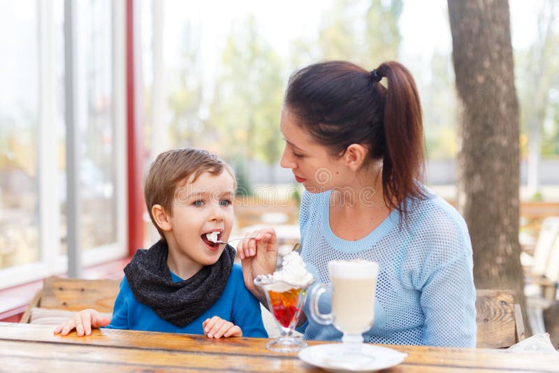 Jeune mère heureuse avec son bébé en café extérieur images stock Jeune mère heureuse avec son bébé en café extérieur images stock