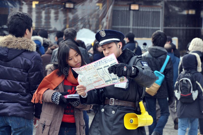 Tourist lost her way during city tiur in Sapporo , Japan. , She brought the map to request assistance from a friendly police. Although there was some language problem, friendliness lead the way. Tourist lost her way during city tiur in Sapporo , Japan. , She brought the map to request assistance from a friendly police. Although there was some language problem, friendliness lead the way