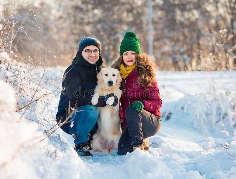 Jeune portrait de couples avec le chien en hiver photographie stock Jeune portrait de couples avec le chien en hiver photographie stock