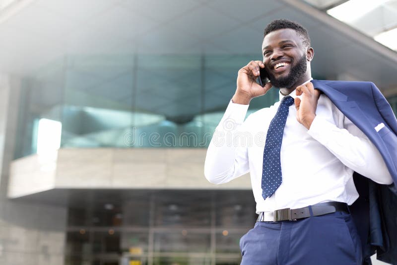 Jeune position d'entrepreneur en dehors du bureau et parler au téléphone portable Copiez l'espace images libres de droits Jeune position d'entrepreneur en dehors du bureau et parler au téléphone portable Copiez l'espace images libres de droits