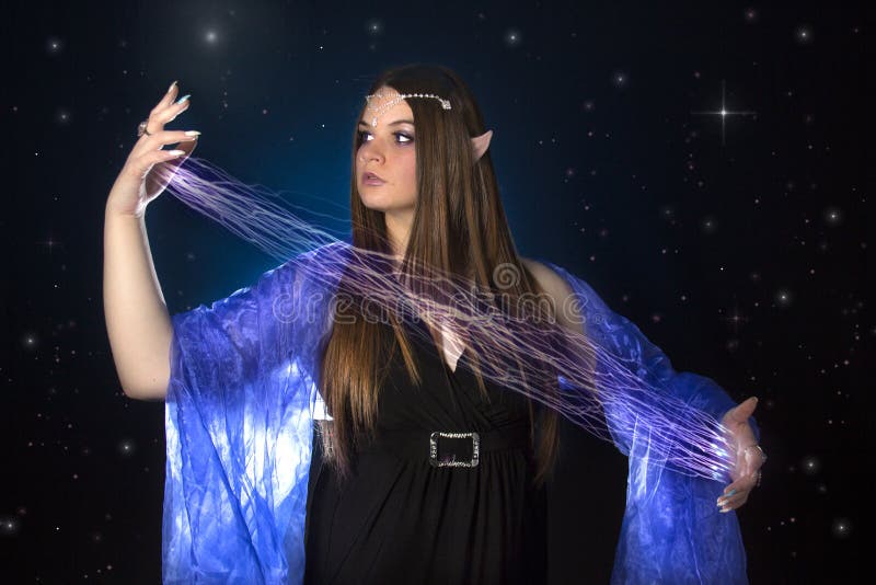 Jeune princesse féminine d'elfe jouant avec la magie la nuit photo libre de droits Jeune princesse féminine d'elfe jouant avec la magie la nuit photo libre de droits