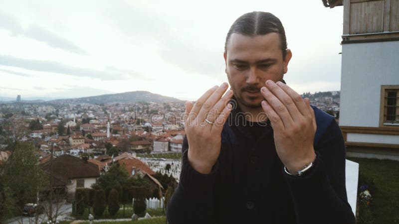 Jeune prière adulte d'homme extérieure avec des mains dans le ciel photographie stock libre de droits Jeune prière adulte d'homme extérieure avec des mains dans le ciel photographie stock libre de droits