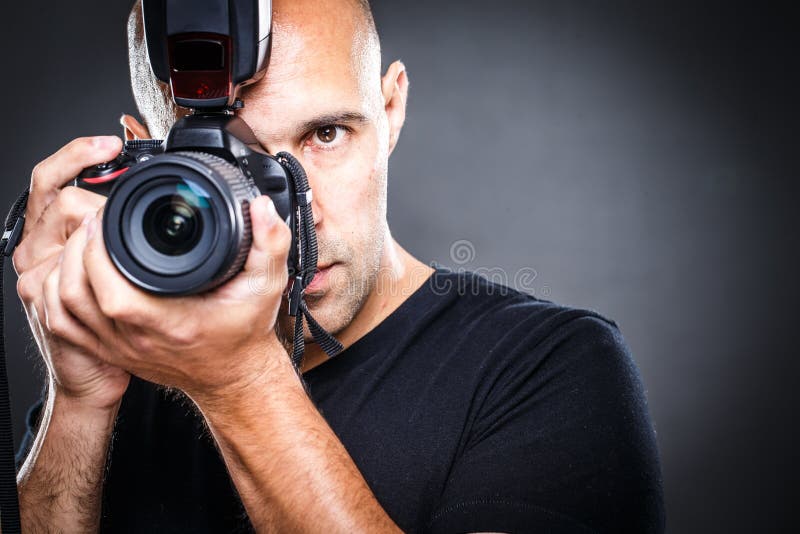 Jeune, pro photographe masculin dans son studio pendant une séance photos image stock Jeune, pro photographe masculin dans son studio pendant une séance photos image stock