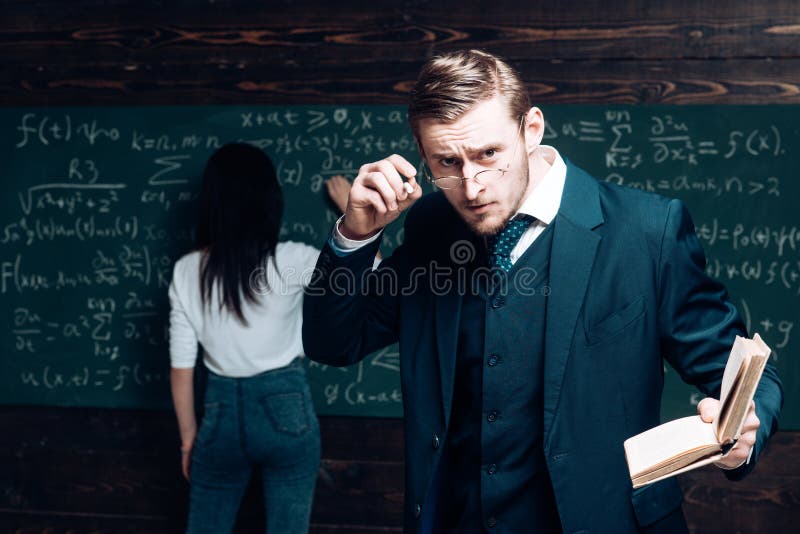 Jeune professeur enlevant ses verres Homme intelligent dans le costume tenant le livre photo stock Jeune professeur enlevant ses verres Homme intelligent dans le costume tenant le livre photo stock