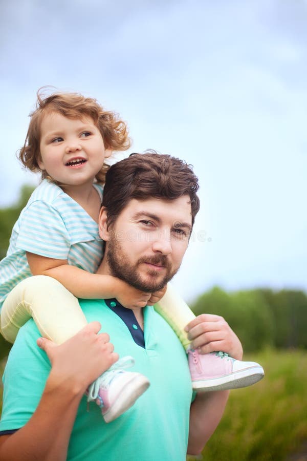 Jeune père et sa fille d'enfant en bas âge, montant sur ses épaules photographie stock Jeune père et sa fille d'enfant en bas âge, montant sur ses épaules photographie stock