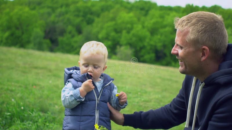 Jeune père heureux jouant avec le petit fils en parc