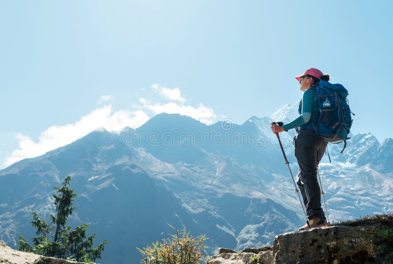 Jeune randonneuse randonneuse randonnée pédestre femme utilisant des poteaux de trekking jouissant d'une vue sur la montagne en h