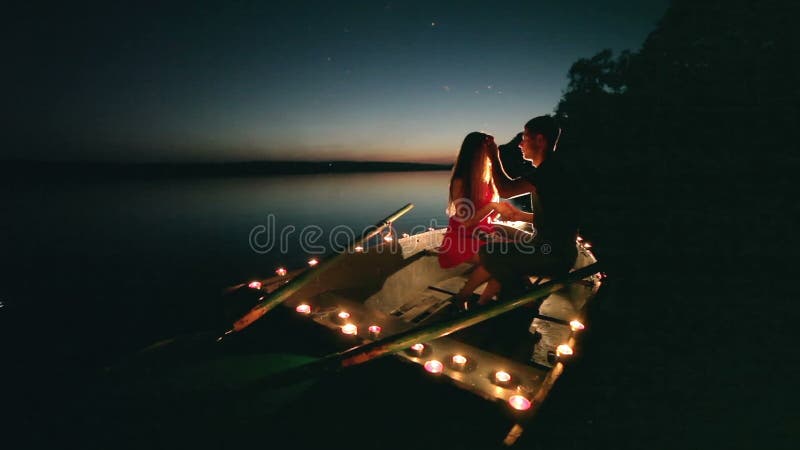 Jeune romance d'amour sur le bateau avec des bougies la nuit