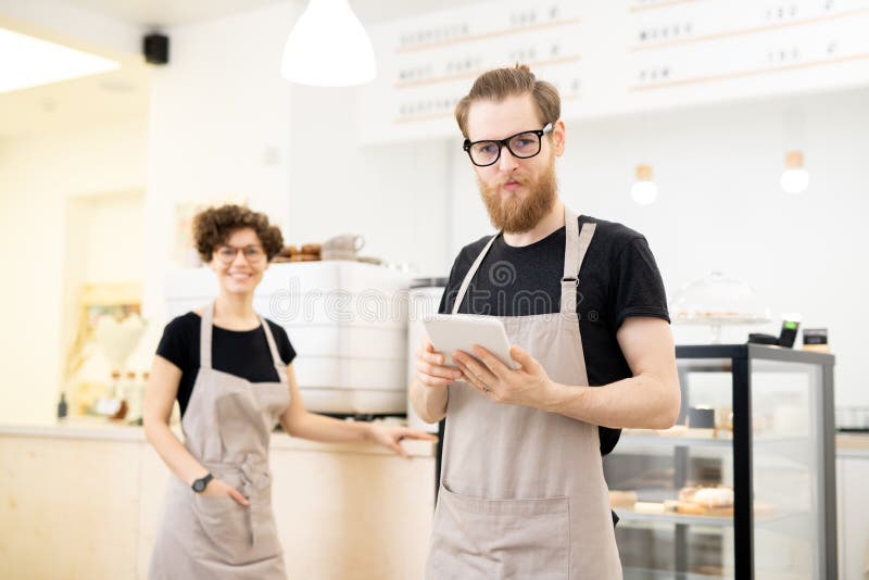 Jeune serveur satisfait dans le café photos libres de droits Jeune serveur satisfait dans le café photos libres de droits