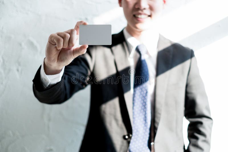 Jeune sourire d'homme d'affaires et tenir la carte de visite professionnelle vierge de visite dans le bureau, concept d'affaires image libre de droits Jeune sourire d'homme d'affaires et tenir la carte de visite professionnelle vierge de visite dans le bureau, concept d'affaires image libre de droits