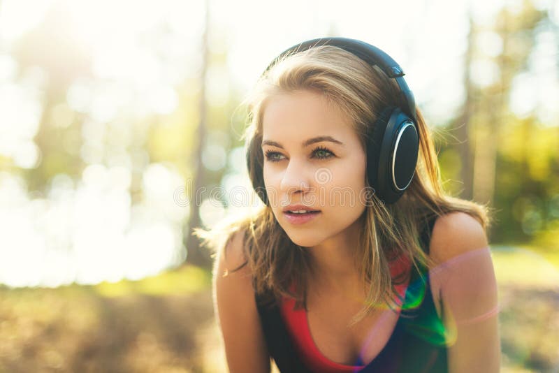 Jeune sportive attirante écoutant les écouteurs de port de musique Sport, forme physique, séance d'entraînement images libres de droits Jeune sportive attirante écoutant les écouteurs de port de musique Sport, forme physique, séance d'entraînement images libres de droits