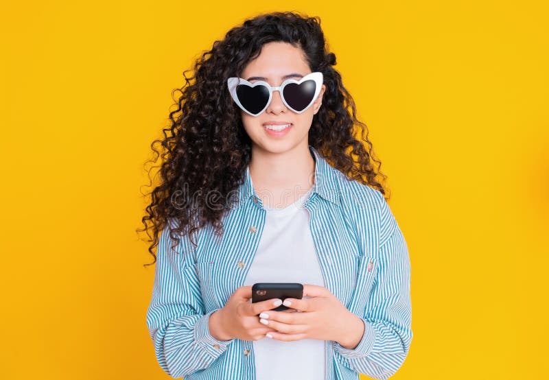 Jeune t?l?phone portable de sourire et de utilisation femelle au-dessus de fond jaune Belle fille de m?tis se tenant et textotant photographie stock Jeune t?l?phone portable de sourire et de utilisation femelle au-dessus de fond jaune Belle fille de m?tis se tenant et textotant photographie stock