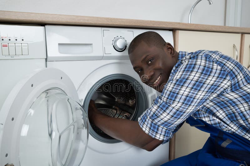 Jeune technicien masculin Fixing Washing Machine images libres de droits Jeune technicien masculin Fixing Washing Machine images libres de droits