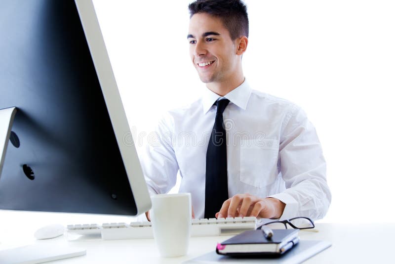 Jeune travail heureux d'homme d'affaires dans le bureau moderne sur l'ordinateur photo libre de droits