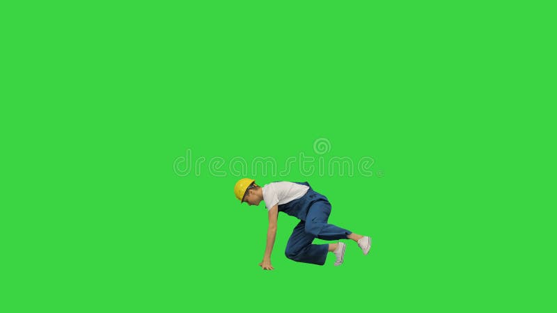 Jeune travailleur de la construction dans le break dance jaune du masque sur ses mains et le sourire à la caméra à l'extrémité d'u banque de vidéos