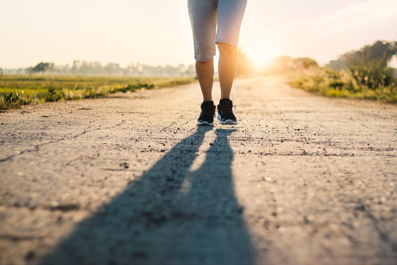 Jeune traînée sportive de femme de forme physique fonctionnant sur la route rurale en été image libre de droits Jeune traînée sportive de femme de forme physique fonctionnant sur la route rurale en été image libre de droits