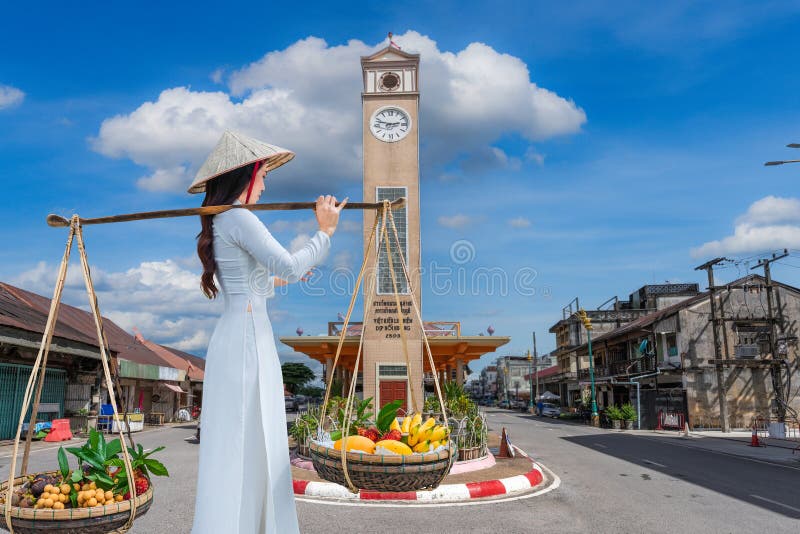 Jeune vietnamienne porte des fruits à vendre à nakhon phanom province thaïlande. traduire : un mémorial pour les vietnamiens photo stock