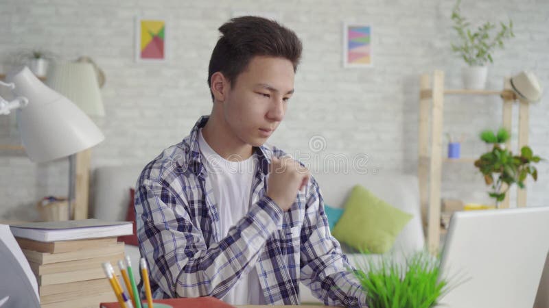 Jeune étudiant asiatique d'homme de portrait à l'aide de l'ordinateur portable