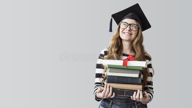 Jeune étudiant gradué regardant loin et livres de transport sur le fond gris image stock Jeune étudiant gradué regardant loin et livres de transport sur le fond gris image stock