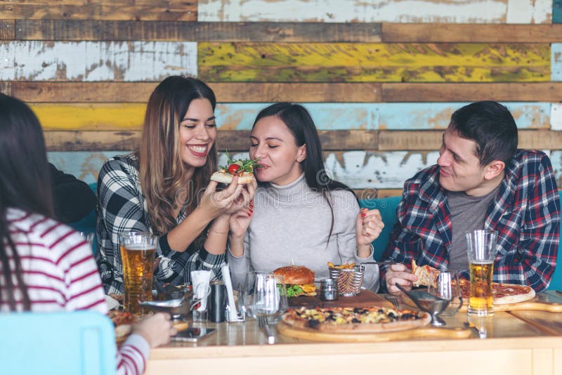 Jeunes amis heureux célébrant avec la pizza et la bière au restaurant de barre photos libres de droits Jeunes amis heureux célébrant avec la pizza et la bière au restaurant de barre photos libres de droits