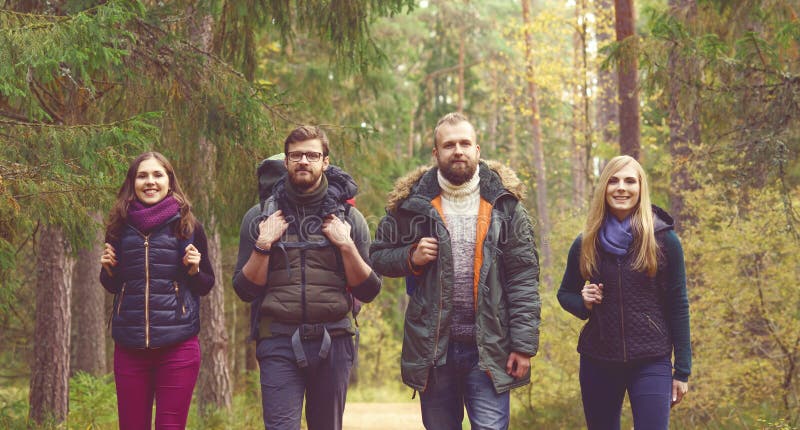 Jeunes amis heureux marchant dans la forêt et appréciant un bon automne photo stock Jeunes amis heureux marchant dans la forêt et appréciant un bon automne photo stock