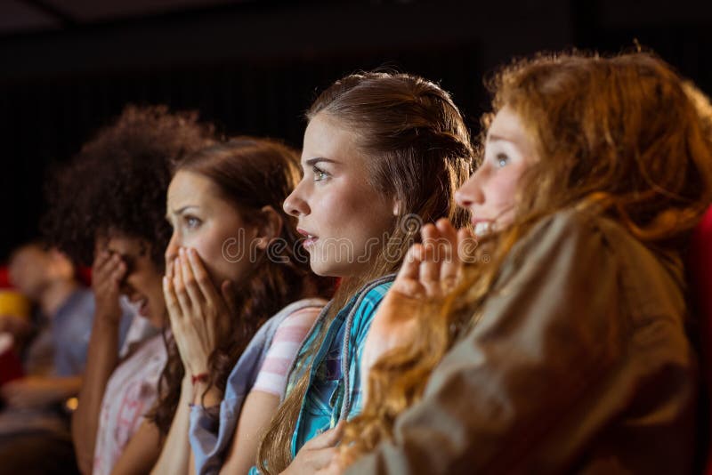 Young friends watching a film at the cinema. Young friends watching a film at the cinema