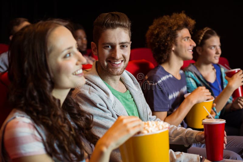 Young friends watching a film at the cinema. Young friends watching a film at the cinema