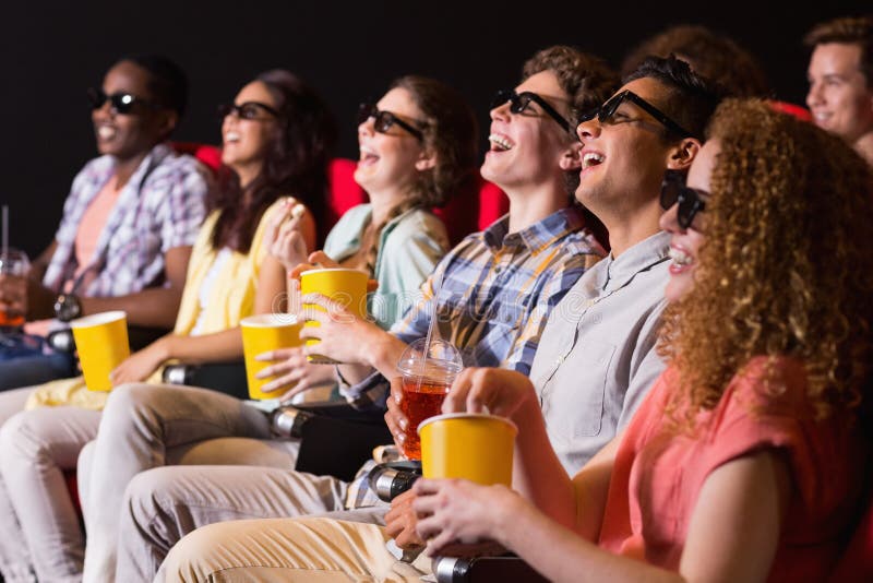 Young friends watching a 3d film at the cinema. Young friends watching a 3d film at the cinema