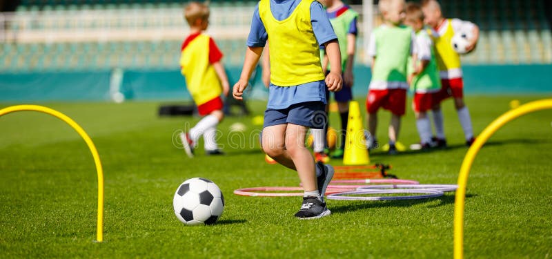 Jeunes athlètes d'enfant s'exerçant avec l'équipement du football Vitesse du football et formation d'agilité