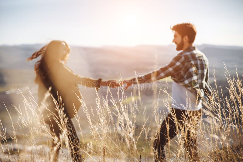 Jeunes beaux couples marchant dehors sur le beau coucher du soleil Paysage romantique parfait pour lovestory images stock Jeunes beaux couples marchant dehors sur le beau coucher du soleil Paysage romantique parfait pour lovestory images stock