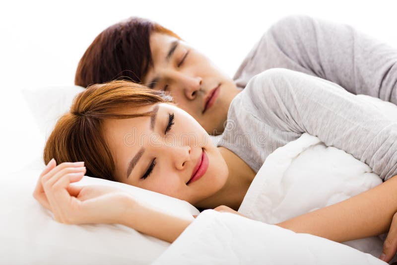 Jeunes beaux couples se situant dans un lit photographie stock