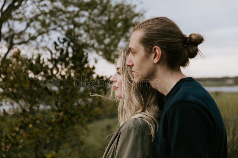Jeunes couples adultes romantiques et affectueux au parc regardant la nature et l'horizon pour des images de portrait photographie stock Jeunes couples adultes romantiques et affectueux au parc regardant la nature et l'horizon pour des images de portrait photographie stock