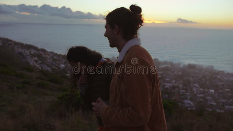 Jeunes couples aimants sur la falaise au coucher du soleil clips vidéos