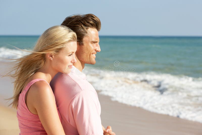 Jeunes couples appréciant des vacances de plage au soleil image stock Jeunes couples appréciant des vacances de plage au soleil image stock