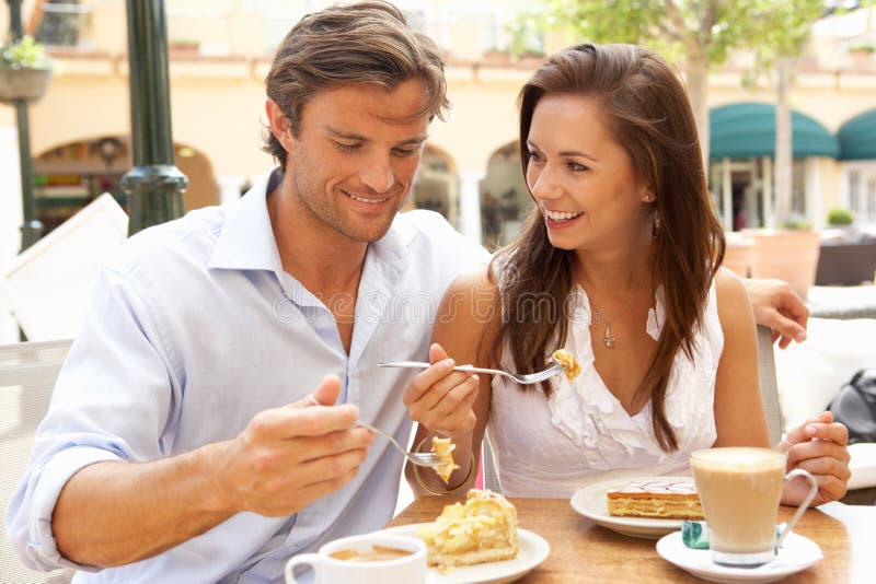 Jeunes couples appréciant le café et le gâteau image libre de droits Jeunes couples appréciant le café et le gâteau image libre de droits