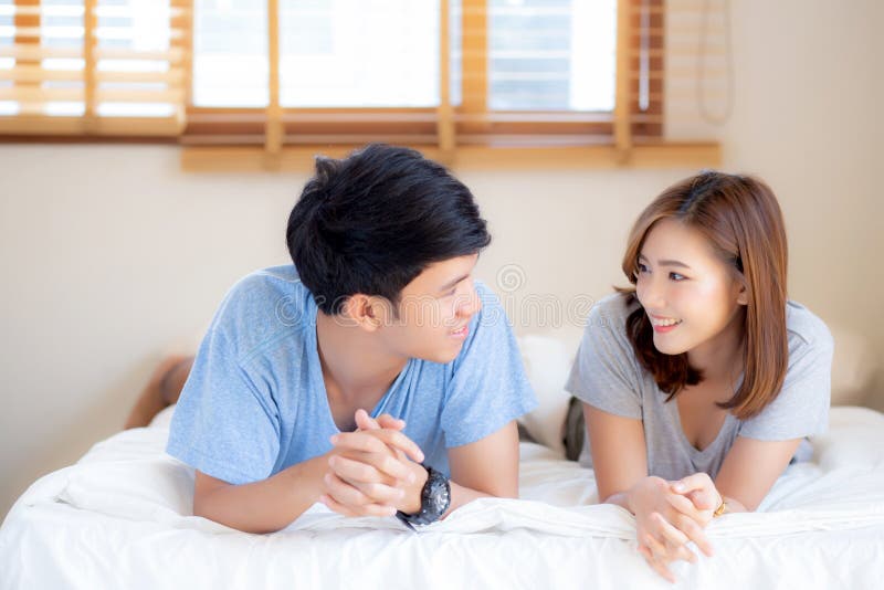 Jeunes couples asiatiques de beau portrait détendre et satisfait ensemble dans la chambre à coucher à la maison, famille s'asseya photo libre de droits Jeunes couples asiatiques de beau portrait détendre et satisfait ensemble dans la chambre à coucher à la maison, famille s'asseya photo libre de droits