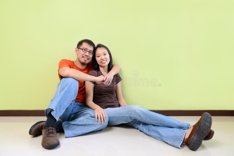 Happy young Asian couples against green wall. Happy young Asian couples against green wall