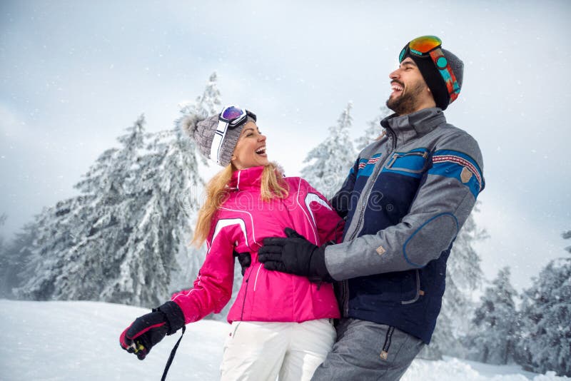 Jeunes couples ayant l'amusement des vacances d'hiver sur la montagne image stock Jeunes couples ayant l'amusement des vacances d'hiver sur la montagne image stock