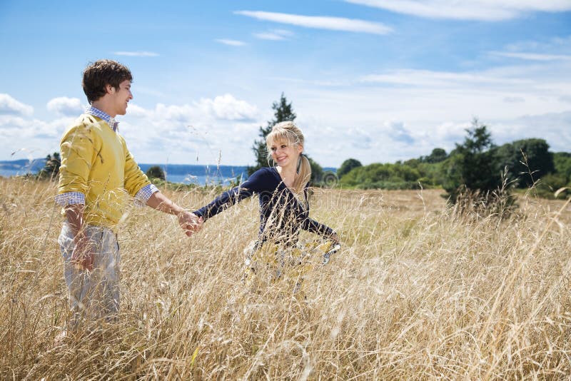 A young caucasian couple in love having fun on a grassy field. A young caucasian couple in love having fun on a grassy field