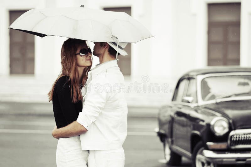Jeunes couples dans l'amour avec le parapluie photo stock Jeunes couples dans l'amour avec le parapluie photo stock