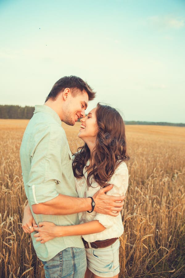 Jeunes couples dans l'amour extérieur Accouplez étreindre Jeunes beaux couples dans l'amour restant et embrassant sur le champ su images libres de droits