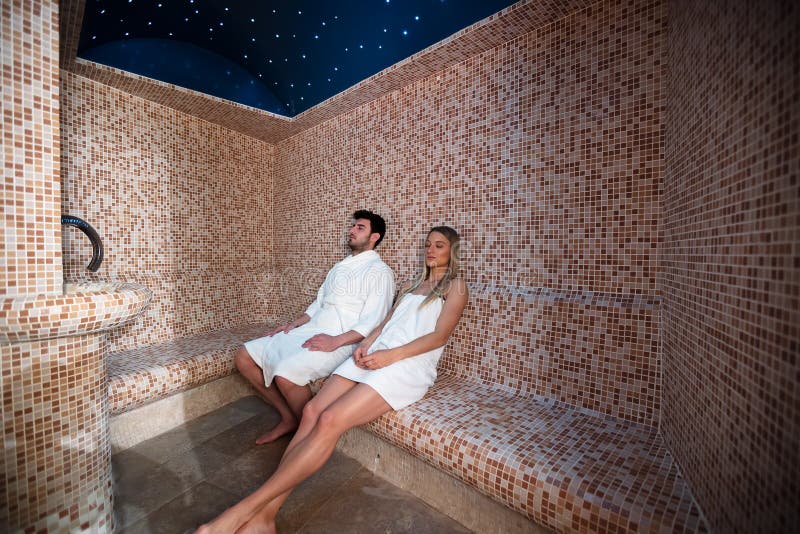 Jeunes couples détendant à l'intérieur du bain turc de sauna de station thermale - deux amants appréciant des vacances dans l'hôt photo libre de droits Jeunes couples détendant à l'intérieur du bain turc de sauna de station thermale - deux amants appréciant des vacances dans l'hôt photo libre de droits