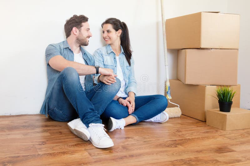 Jeunes couples enthousiastes attendant avec intérêt d'entrer dans une nouvelle maison photo libre de droits Jeunes couples enthousiastes attendant avec intérêt d'entrer dans une nouvelle maison photo libre de droits